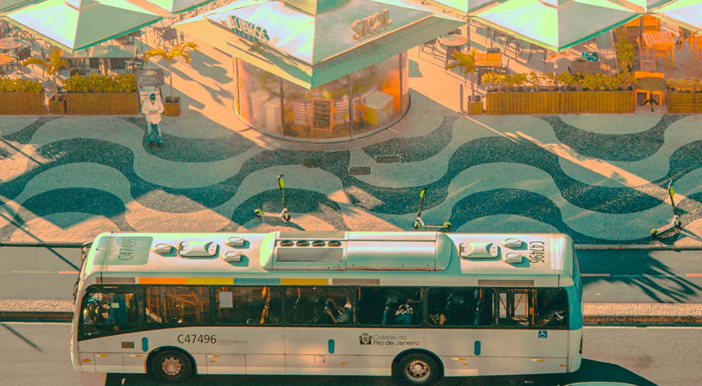 Foto do calçadão Copacabana. Passando ônibus do na avenida. Mosaico no calçadão.