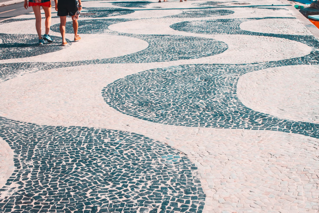 Caçadão de Copacabana, foto diurna. Pessoas caminhando.