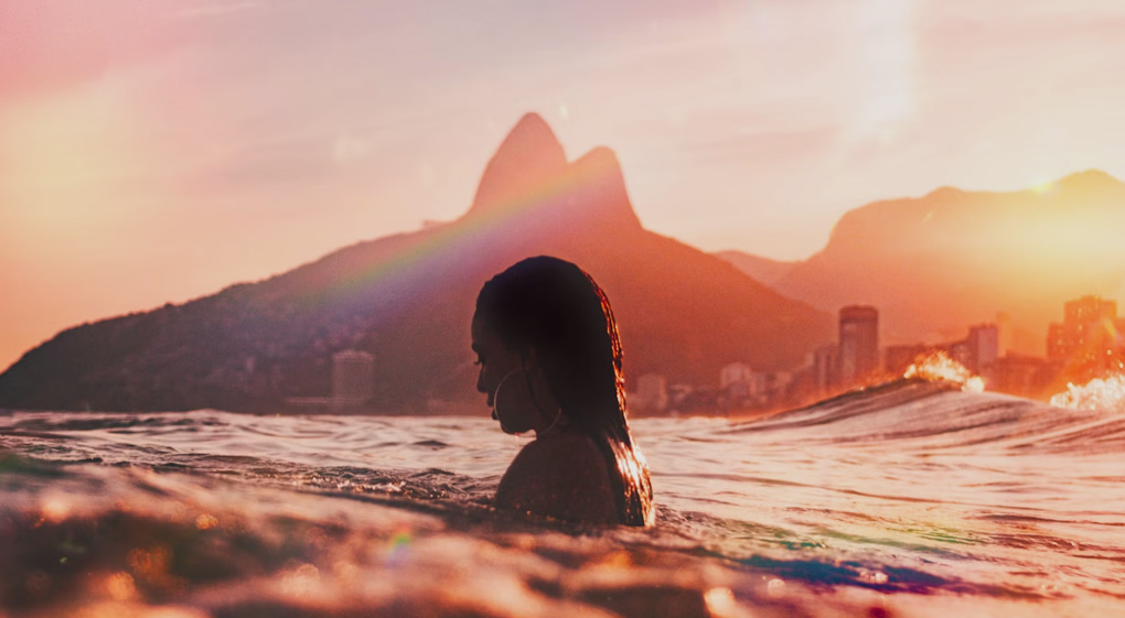 Por do sol em Copacabana, mulher na água. Paisagem de fundo.