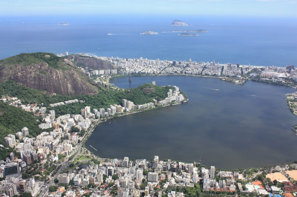 Lagoa e cidade do Rio vista do alto em dia de sol.