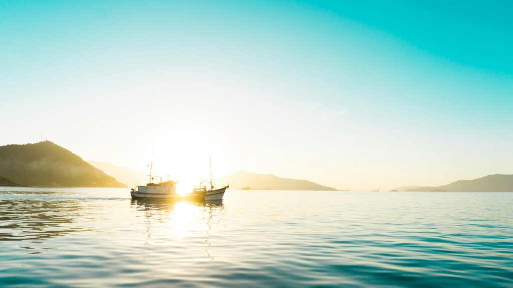 Barcos no mar em Angra, luz do sol ilumina, por do sol.
