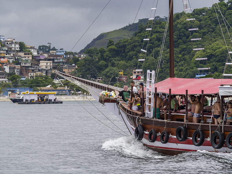 Foto com barco chegando a uma das ilhas de Angra. Barco cheio de turistas.