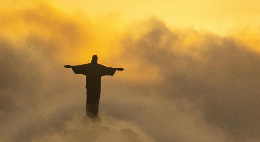 Cristo Redentor visto acima das nuvens, por do sol.