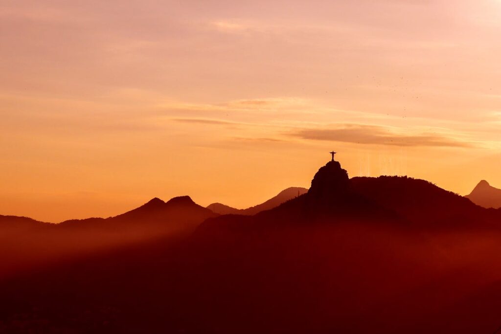 Cristo Redentor, por do sol, estátua vista de longe.