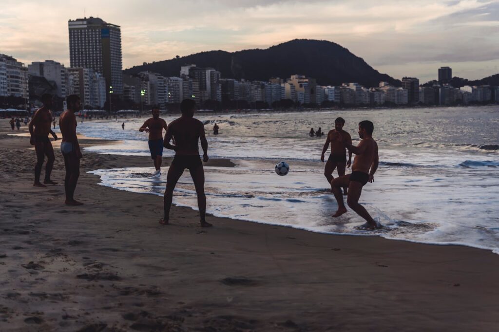 Praia no Rio de Janeiro, pessoas jogando na areia.