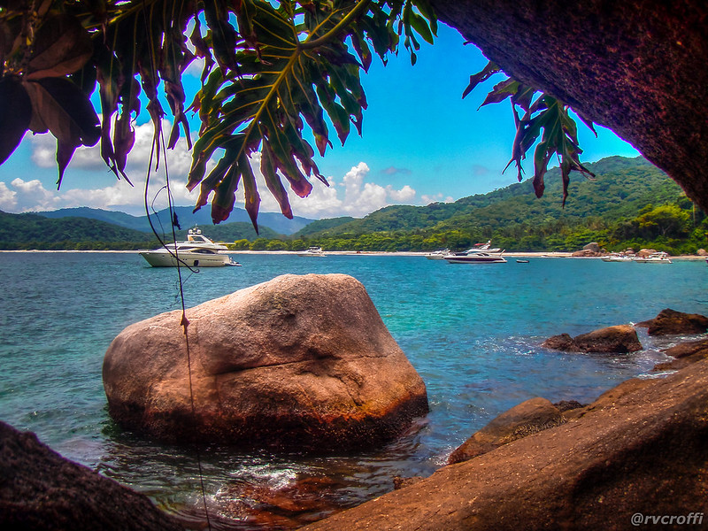 Barcos no mar, foto mostra a vista de uma de barcos nas águas de Ilha Grande. Pedras na água dão beleza ao lugar.