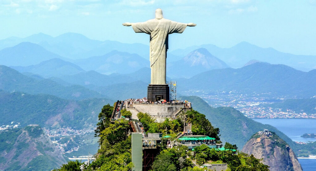 Cristo Redentor visto durante o dia. Pessoas visitando o monumento.