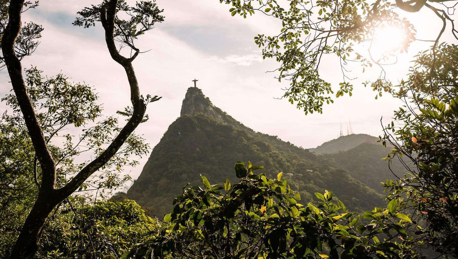Roteiro de 5 Dias no Rio de Janeiro: Praias, Trilhas e Cultura 1 Vista do Cristo Redentor emoldurado pela copa das árvores da Floresta da Tijuca no Rio de Janeiro