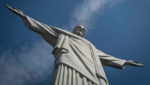 Vista aérea do Cristo Redentor no alto do Corcovado com a cidade do Rio de Janeiro ao fundo