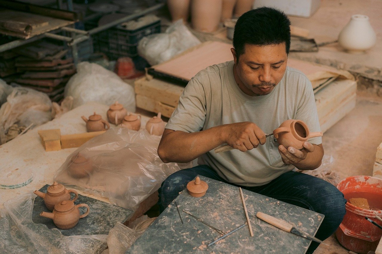 Feira Hippie de Ipanema: Horários, Dicas e o Que Comprar 2 Artesão pintando cerâmica à mão - artesanato da Feira Hippie de Ipanema