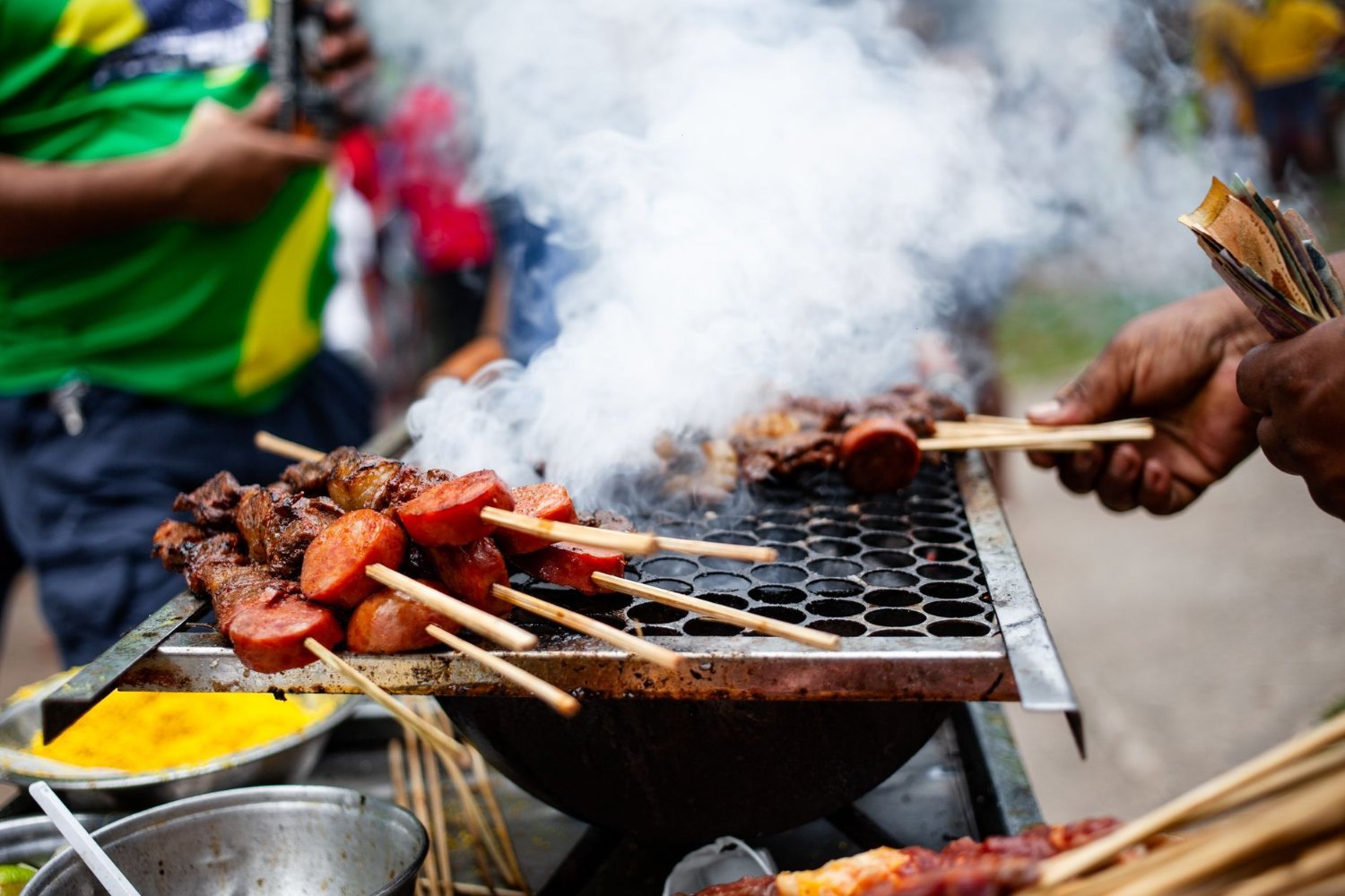 Feira de São Cristóvão: o Nordeste no Coração do Rio 4 Espetinhos de carne grelhando com fumaça em barraca nordestina da feira