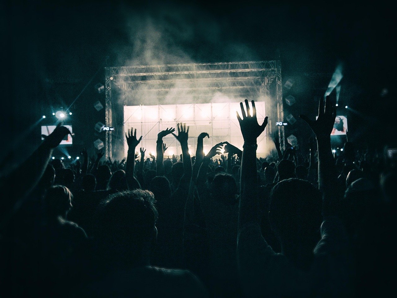 Festival de Inverno Rio 2026: lineup, ingressos e como chegar 2 Público animado em festival de música ao ar livre com luzes coloridas no palco