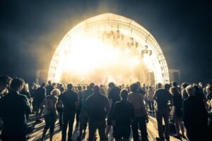 Show ao ar livre à noite com palco iluminado e plateia em festival de música como o Festival de Inverno Rio