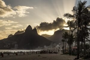 Vista aérea da Praia da Prainha no Rio de Janeiro, com mar azul e morros cobertos de mata