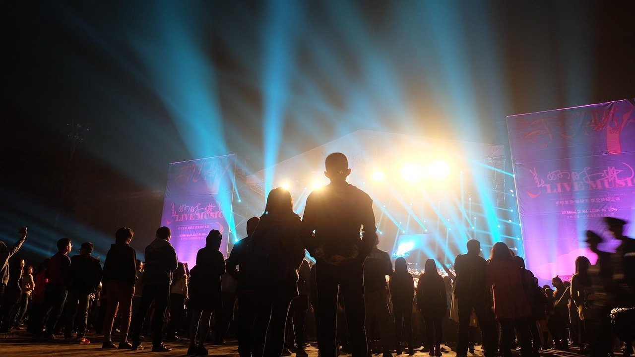 Rock in Rio 2026: datas, lineup, ingressos e como chegar 1 Silhuetas de público em frente ao palco iluminado em festival de música, como o Rock in Rio
